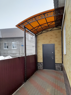 Навес из поликарбоната односкатный в виде пристройки к дому с декоративной ковкой
